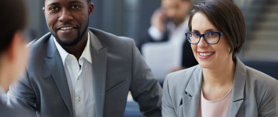 Two persons looking at another person speaking