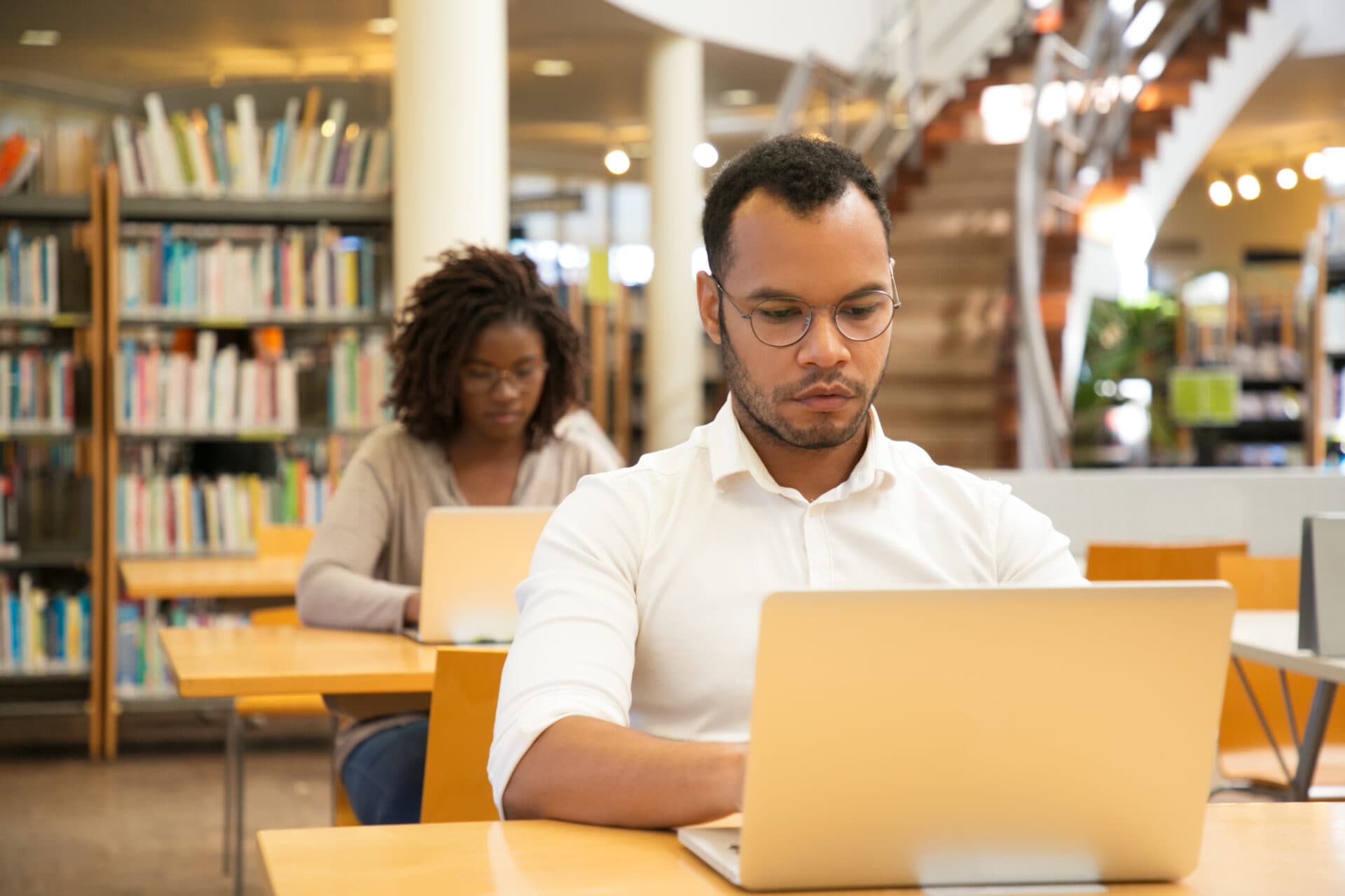 Focused male Latin student working on computer